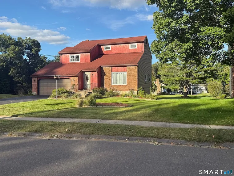 Two-storey home with red siding, a brick front, a red roof and a two-car garage on a wide lawn at 78 Country Club Drive, Windsor, Connecticut